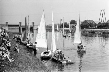 Parada żaglówek na Wiśle na wysokości Nowej Huty. Początki żeglarstwa w Krakowie-Nowej Hucie sięgają 1955r. Utworzono wówczas Zakładowy Klub Morski z czterema sekcjami: kajakową, wioślarską motorowodną i żeglarską przy Zjednoczeniu Przemysłowym Budowy Huty im. Lenina. Rozpoczęto również budowę przystani wodnej Nad Wisłą u wylotu ulicy Klasztornej.
22.07.1955 - uroczyste otwarcie przystani w nowo wybudowanych hangarach, a na wodę spłynęły oprócz kajaków 4 jachty: Omega, dwa Finny i BM.
W 1959r. nastąpiła zmiana nazwy Klubu na Yacht Klub „Budowlani