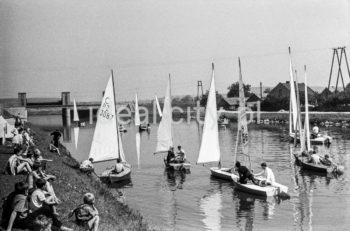 Parada żaglówek na Wiśle na wysokości Nowej Huty. Początki żeglarstwa w Krakowie-Nowej Hucie sięgają 1955r. Utworzono wówczas Zakładowy Klub Morski z czterema sekcjami: kajakową, wioślarską motorowodną i żeglarską przy Zjednoczeniu Przemysłowym Budowy Huty im. Lenina. Rozpoczęto również budowę przystani wodnej Nad Wisłą u wylotu ulicy Klasztornej.
22.07.1955 - uroczyste otwarcie przystani w nowo wybudowanych hangarach, a na wodę spłynęły oprócz kajaków 4 jachty: Omega, dwa Finny i BM.
W 1959r. nastąpiła zmiana nazwy Klubu na Yacht Klub „Budowlani