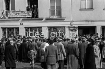 Motocykliści na Placu Pocztowym na osiedlu A-1 Północ (Willowe), wyścig motocyklowy. W styczniu 1950 roku został zlikwidowany Automobilklub Polski. Na jego miejsce powstał Polski Związek Motorowy (jako efekt połączenia Automobilklubu Polski z 1909 roku i Polskiego Związku Motocyklowego z 1924 roku). Chcąc ratować AP wraz z PZM postanowiono wystąpić do Ministra Komunikacji o wprowadzenie Automobilklubu do Rady Turystycznej jako przedstawiciela turystyki motorowej oraz włączenie AP do planu 6 – letniego. Uchwalono wspólne postanowienia, takie jak przebudowa struktury organizacji (włączenie ośrodków wiejskich), zaproszenie do Zarządu działaczy ZMP, przeszkolenie działaczy zgodnie z intencjami władz PZPR, powołanie ośrodków dla młodzieży robotniczej i wiejskiej, jak również zakupienie dla najbardziej zdolnych sprzętu oraz udostępnienie pomocy technicznej. Powołano wspólnie odnowioną organizację czyli PZM. Z początkiem 1956 roku Zarząd Główny PZM wydał wytyczne do reorganizacji terenowych agend. Zarządy Okręgowe przystąpiły do organizacji „Automobilklubów”, które powstały w miejscu Ośrodków Szkolenia. Automobilkluby miały za zadanie, oprócz działalności sportowej, rozwijać struktury szkoleniowe ze sprzętem i zapleczem oraz pełnić dalej rolę organizatorów imprez. W ten sposób powstały kolejne organizacje w ramach PZM, m.in.: Automobilklub Kraków czy Automobilklub Nowa Huta z siedzibą przy ul. Klasztornej 1.  W 1957 roku PZM dokonał kolejnej reorganizacji oddziałów. Powołano ponownie Automobilklub Polski oraz wojewódzkie oddziały Automobilklubów. 1 czerwca 1957 roku w Krakowie reaktywowano Automobilklub Krakowski oraz przejęto lokal w Nowej Hucie po tamtejszym klubie, tworząc Ośrodek Techniczny. II połowa lat 50. XXw.

fot. Wiktor Pental/idealcity.pl

