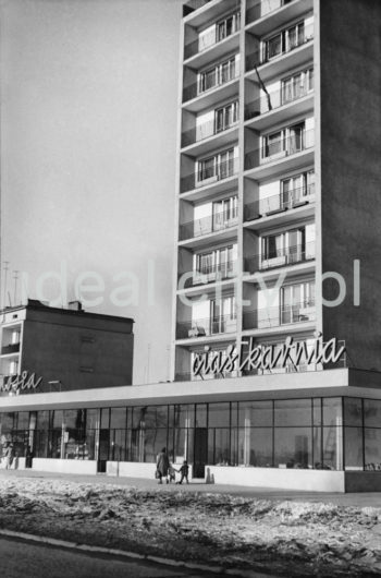 Dziesięciopiętrowy punktowiec (wybudowany po 1957 roku) z pawilonem handlowo-usługowym Ciastkarnią 