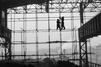 Kombinat metalurgiczny im. Lenina, fragment jednej z hal produkcyjnych, montaż rusztowań, w tle widoczne zabudowania huty, lata 60. XXw.


fot. Henryk Makarewicz/idealcity.pl

