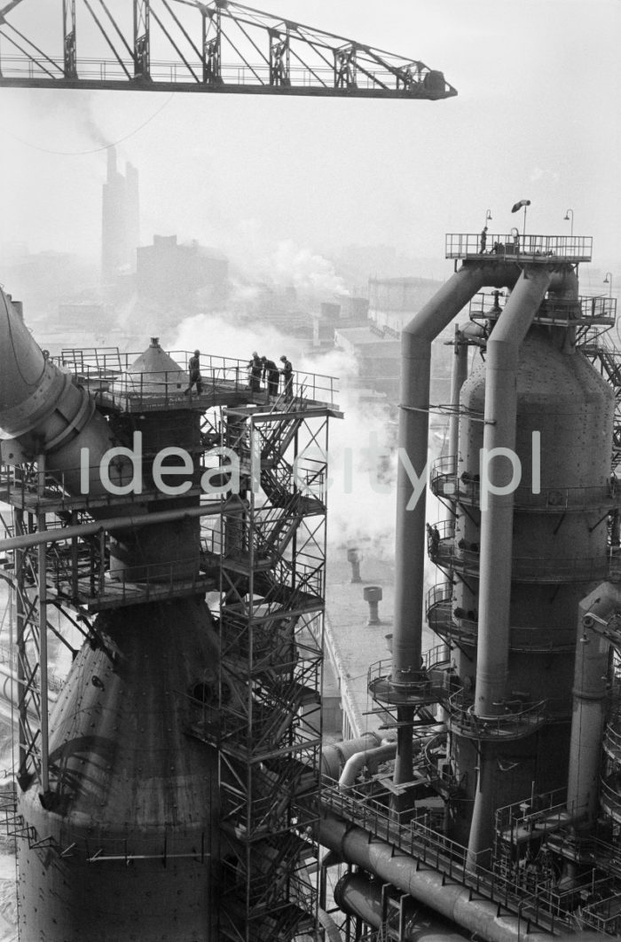 Lenin Metallurgical Combine, Blast Furnace Plant. 1960s.
Equipment for cleaning gas, comprising an electrostatic dust collector and wet gas cleaning system. The process of gas cleaning had several stages: primary cleaning in the electrostatic dust collector (removing larger dust particles), cooling gas and cleaning it in scrubbers.

Kombinat metalurgiczny im. Lenina, rejon Wielkiego Pieca, lata 60.
Widoczny zespół urządzeń do oczyszczania gazu, złożony z odpylnika statycznego oraz mokrej części oczyszczalni. Proces oczyszczania gazu odbywał się w kilku etapach: wstępnego oczyszczenia gazu w odpylniku statycznym (usuwanie grubszych frakcji pyłu), chłodzenia gazu i oczyszczani go w płuczce wieżowej („skruberze”), oczyszczania w płuczkach.

Photo by Henryk Makarewicz/idealcity.pl

