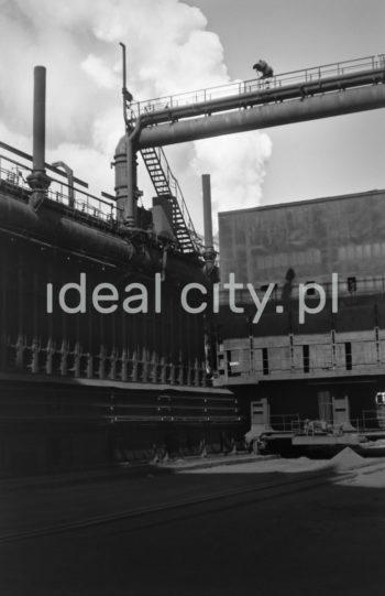 Lenin Metallurgical Combine, coke oven battery. 1960s.
Coking Plant No. 1 was constructed in 1954-6. The eight-battery group of coke ovens included two sets four batteries each and two screening units. Gas was steered from the battery to sections of condensing and recovering coal derivates no. 1 with a later extension housing a Thylox gas desulfator. Condensing and purifying gas produced tar, ammonia water, BTX – pyrimidines and sulphur. The first stage of the construction of Coking Plant no. 2 was finished in 1966. There were 12 coke oven batteries operating in the 1970s.

Kombinat metalurgiczny im. Lenina, bateria koksownicza, lata 60.
Koksownia nr 1 została wybudowana w latach 1954-1956. Ośmiobateryjny blok pieców koksowniczych składał się z dwóch zespołów po cztery baterie oraz dwóch sortowni. Gaz z baterii kierowany był do oddziałów kondesacji i odzysku węglopochodnych nr 1 z dobudowaną odsiarczalnia gazu systemem Thylox. Na drodze kondensacji i oczyszczania gazu otrzymywano smołę, wodę amoniakalną, benzol – zasady pirydynowe oraz siarkę. Pierwszy etap Koksowni nr 2 wybudowano w 1966 roku. W latach 70. działało 12 baterii koksowniczych.

Photo by Henryk Makarewicz/idealcity.pl
