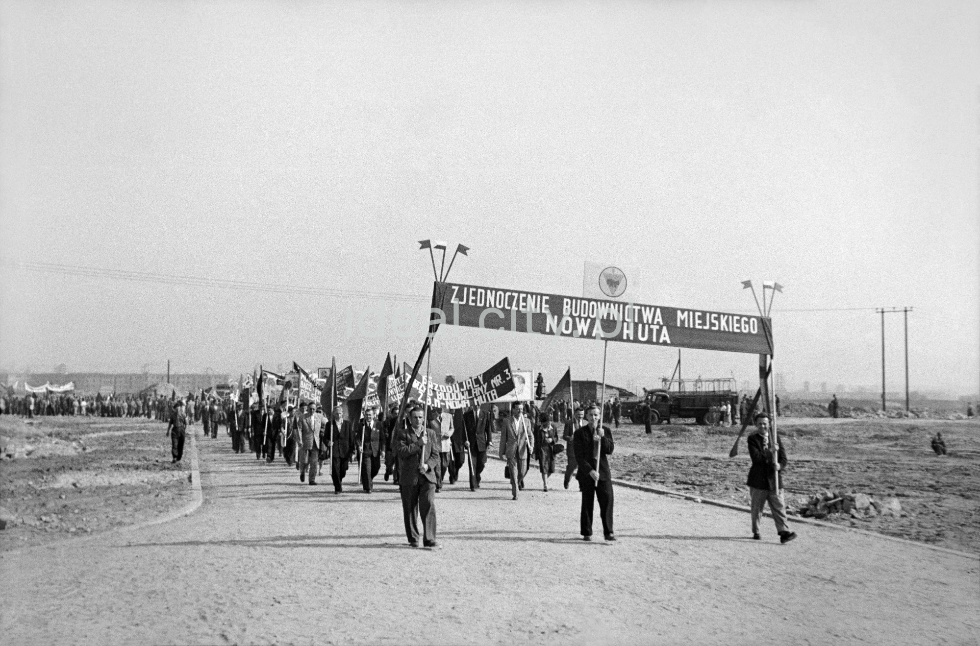 Odświętnie ubrani ludzie idą dynamicznie w pochodzie.