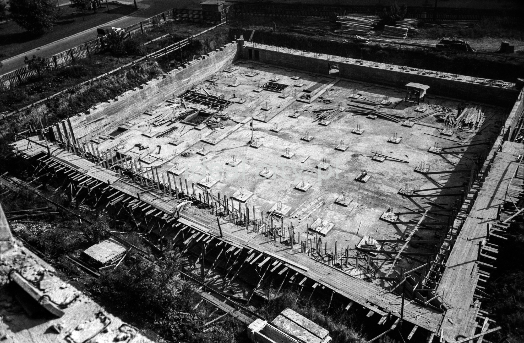 Ujęcie z góry na zbrojone fundamenty budynku o podstawie kwadratu.